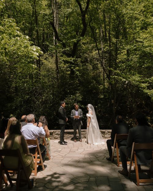 Raynita and Charlie at the altar in the woods at Spence Cabins