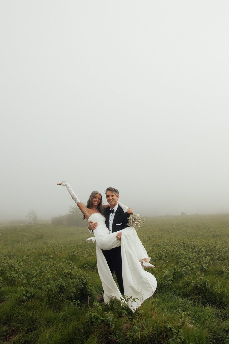 Austin carrying Taylor across a foggy Roan Mountain field