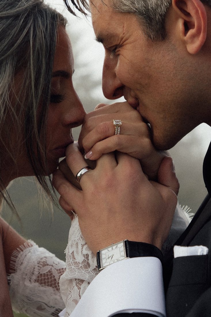 Close up of Taylor and Austin's clasped hands and wedding rings