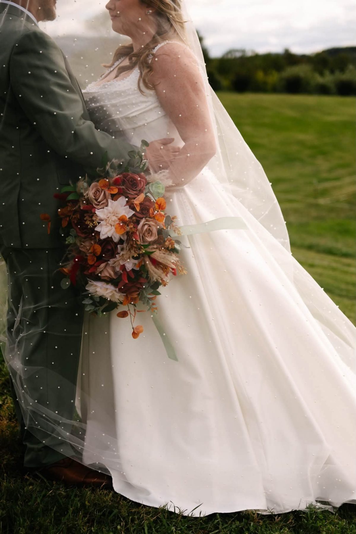 Christine and Graham embracing under the veil