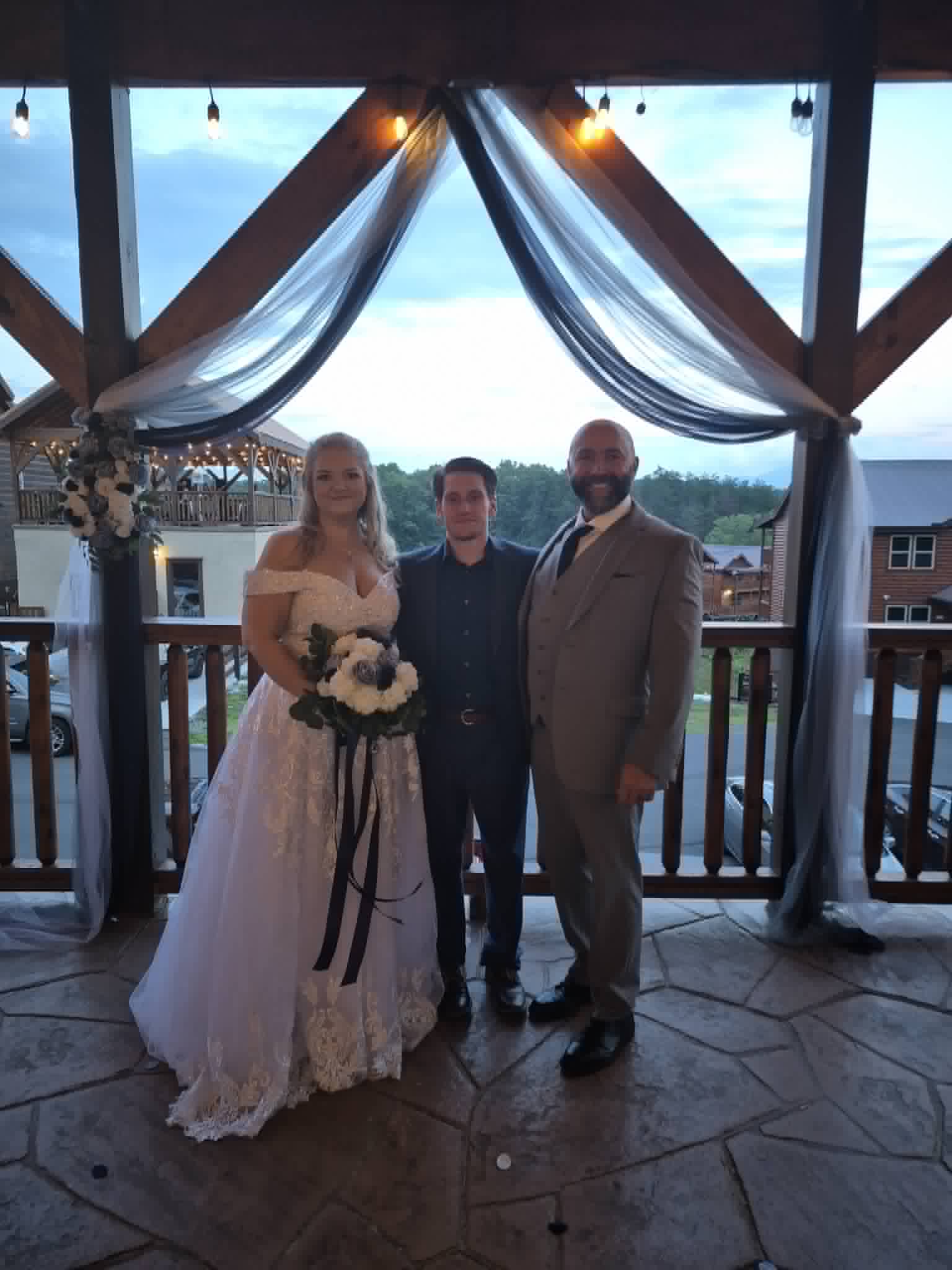 Josh Wilbanks and his bride Nikki with Nathan under the pavilion after their ceremony