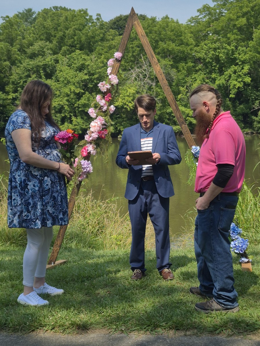Kyle Brown and Brandy's lakeside elopement under the flower arch, with Nathan officiating