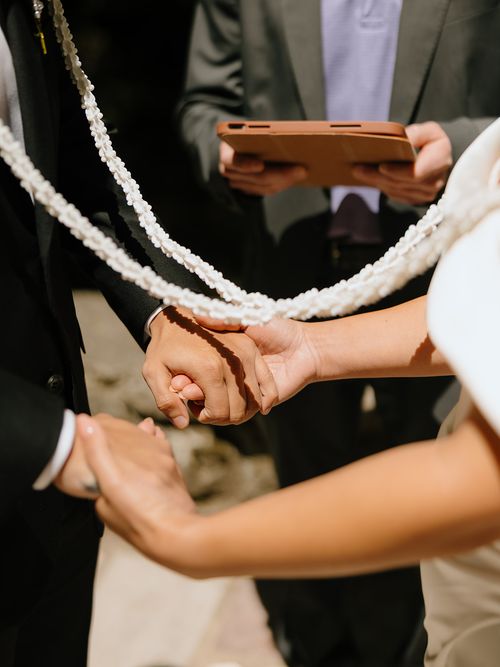 The wedding lasso draped over Raynita and Charlie's clasped hands during their ceremony